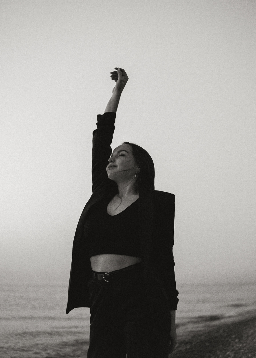 Black and White Photo of Woman Raising Her Hand